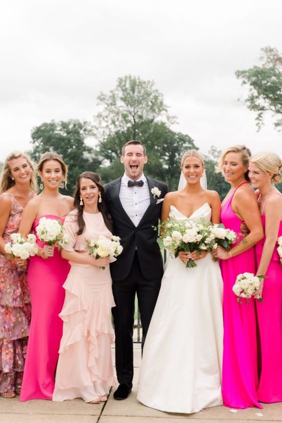 bridesmaids wearing light pink, hot pink and dusty pink mismatching maxi dresses look fantastic and trendy