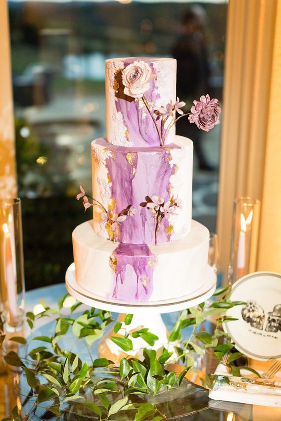 a chic spring wedding cake in white, with purple watercolors, with purple and neutral dried blooms is a refined and beautiful idea