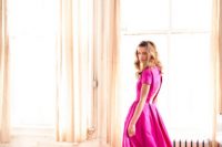 08 a bride rocking an unusual hot pink A-line wedding dress with a cutout back, short sleeves and a pleated full skirt looks bold and stylish