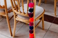 08 a bright pompom garland is a great piece to accent a wedding chair and it’s a very budget-friendly solution