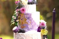 09 a dreamy and whimsical wedding cake with textural buttercream and a watercolor purple tier, with gold leaf, purple macarons, berries and bright blooms for a fairytale wedding