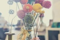 10 a bright fiesta wedding centerpiece with colorful pompoms on sticks, with colorful embroidery hoops and numbers is amazing