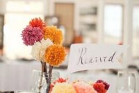 11 a cluster wedding centerpiece of jars with colorful pompoms on sticks is an easy idea to rock and such piece are easy to DIY