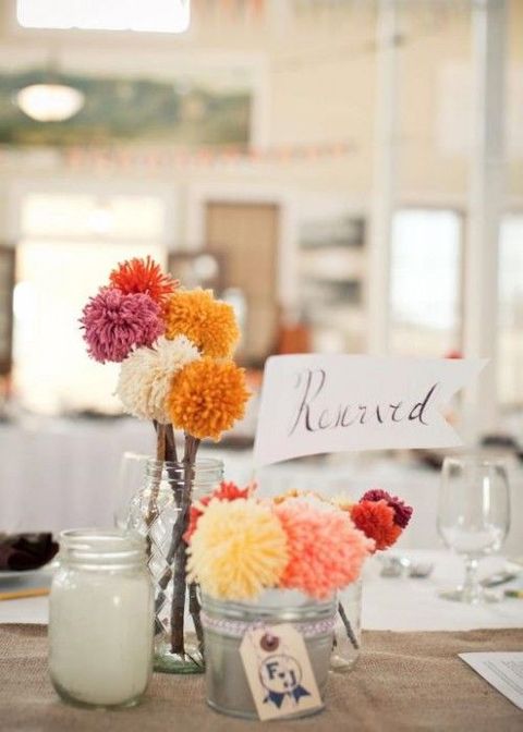 a cluster wedding centerpiece of jars with colorful pompoms on sticks is an easy idea to rock and such piece are easy to DIY