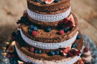 12 a naked boho wedding cake topped with fresh berries and figs, with blooms and greenery on top plus white lace ribbon decor