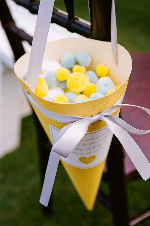a large yellow cone with white, grey and yellow pompoms instead of rice for wedding exit is a very fun and creative idea, later you may reuse them