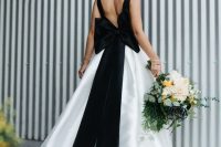 13 a modern wedding ballgown with black straps on the cutout back and an oversized black bow, with a train for an ultra-modern look