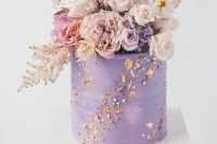 15 a jaw-dropping purple wedding cake decorated with dried flower petals and beads, with super lush pastel and lilac florals on top