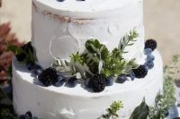 15 a naked two-tier wedding cake with greenery and berries is a lovely idea to rock at many weddings