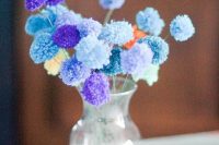 18 a simple wedding decoration – a glass vase with colorful yarn pompoms on sticks is a great example of a wedding centerpiece