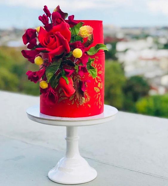 a bold red wedding cake with gold glitter, with burgundy and red blooms, leaves and billy balls is an amazing idea for a modern and bright wedding
