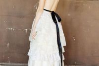 19 a romantic A-line white lace wedding dress with lace and ruffle tiers plus a train, a black silk ribbon that creates a criss cross back and a bow