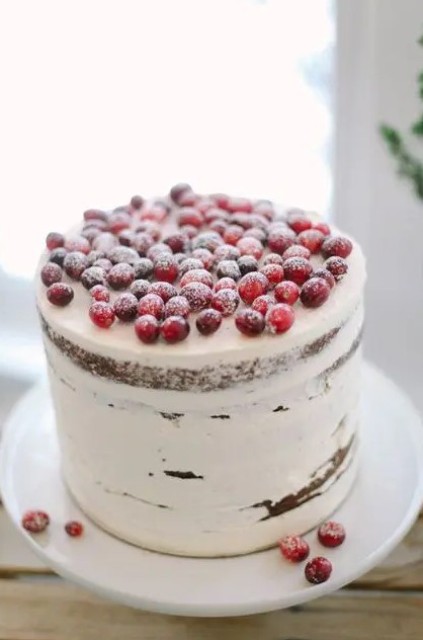 a naked wedding cake topped with sugared berries is a stylish and chic dessert for a winter wedding