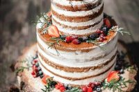 21 a naked wedding cake topped with sugared berries, greenery served on a wood slice for a rustic wedding