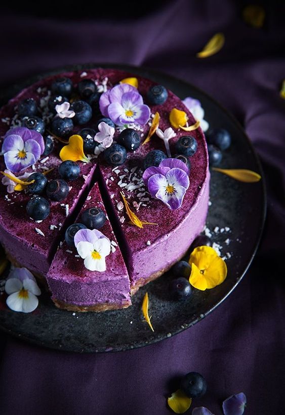 a purple mousse wedding cake topped with fresh edible blooms, berries and coconut is a gorgeous idea for a summer wedding