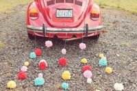 21 a wedding car with colorful pompom garlands instead of tin cans – much quieter and gives a unique touch to your wedding escape