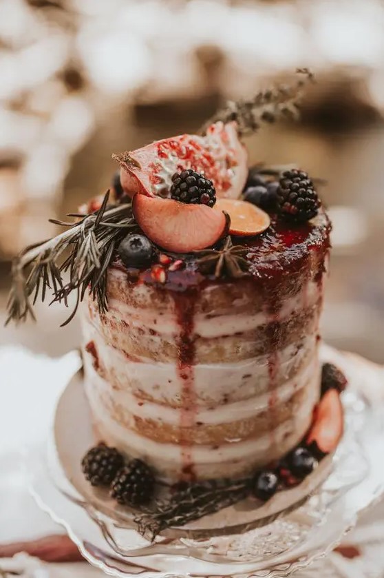 a naked wedding cake with berry drip, fresh fruits and berries is a gorgeous idea for a fall wedding