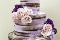 22 a purple naked wedding cake with purple and lilac blooms and a gold calligraphy topper is a lovely idea for a bright wedding