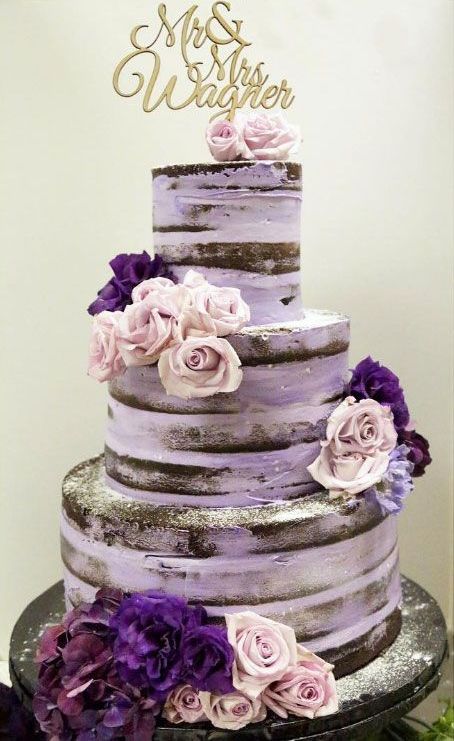 a purple naked wedding cake with purple and lilac blooms and a gold calligraphy topper is a lovely idea for a bright wedding