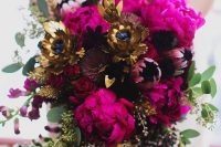 23 a dramatic bridal bouquet of hot pink peonies, deep purple blooms, gold faux flowers, greenery and gilded seeded eucalyptus