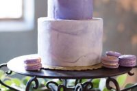 23 a refined modern wedding cake with a violet and a purple marble tier, with gold foil and matching macarons around is wow