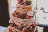 24 a naked wedding cake with fresh berries and pink sugar blooms is a delicious dessert for a summer rustic wedding