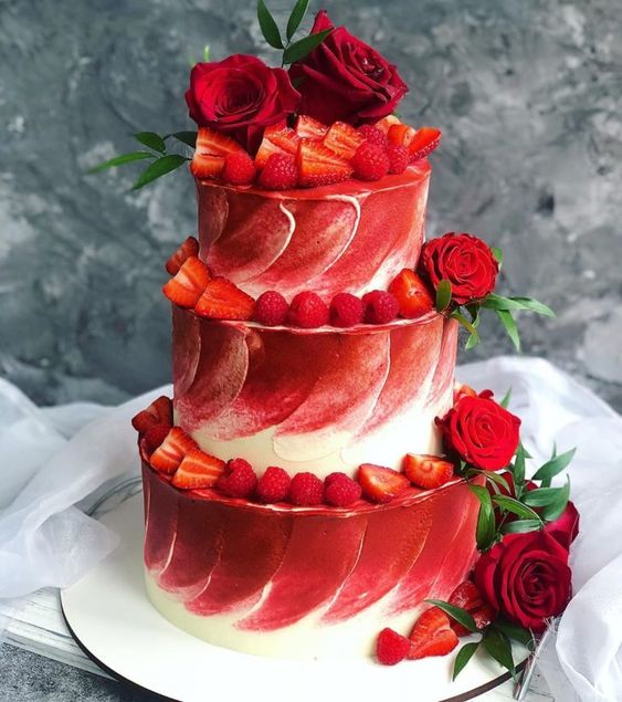 a red and white textural wedding cake topped with red roses and greenery and strawberries and rapsberries is a gorgeous idea for a modern wedding