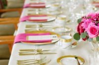 25 a glam wedding tablescape with hot pink blooms and greenery, gold chargers and hot pink napkins, gold cutlery and gold rimmed mugs