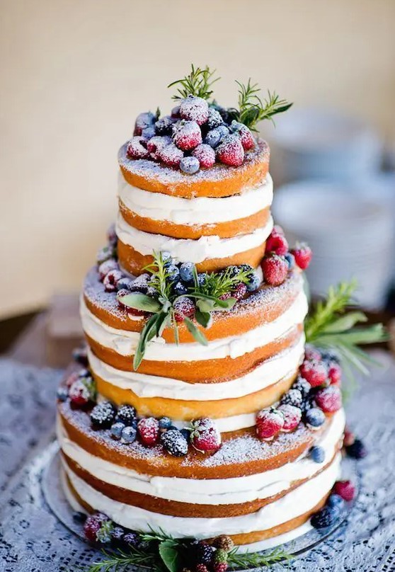 a naked wedding cake with greenery and sugared berries is a perfect option not only for a winter wedding