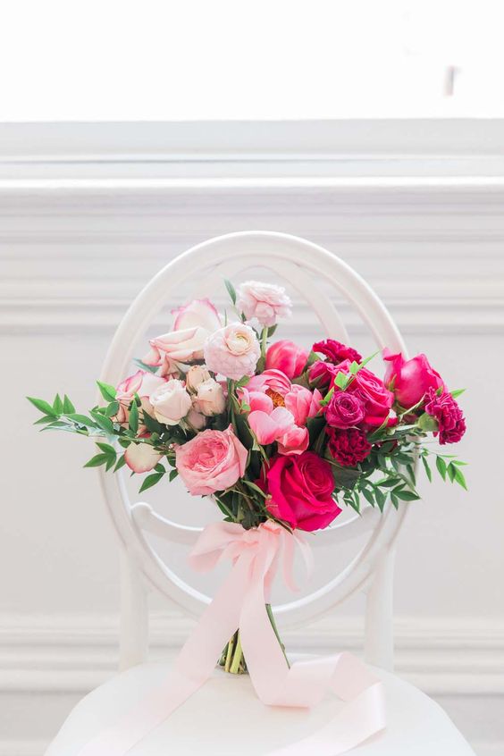 a gorgeous ombre wedding bouquet from blush to light pink and hot pink, with greenery and blush ribbons is a lovely idea for a glam bride