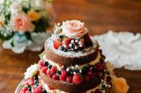 26 a naked wedding cake with lots of berries and fresh blooms, with greenery is a lovely solution for a spring or summer boho wedding cake