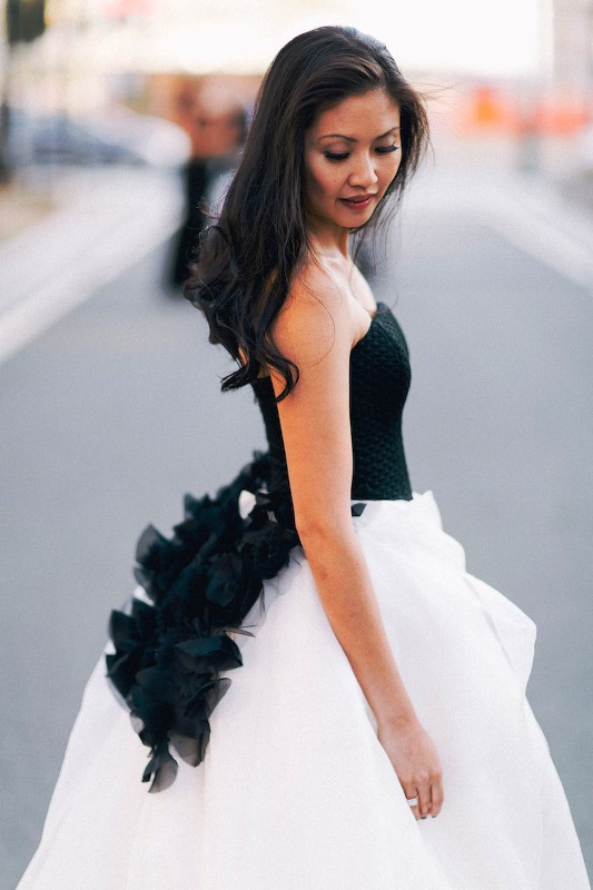 a wedding ballgown with a black corset bodice with black ruffles on its back and a white full skirt is a stunning contrasting idea