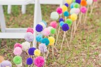 27 colorful pompoms on sticks are great to line up the aisle, you can DIY lots of them and brign a bold touch to the wedding aisle