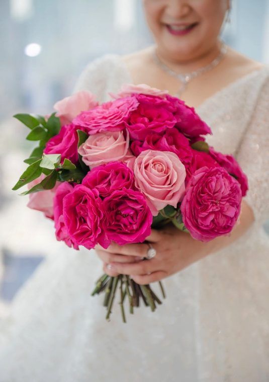 a gorgeous wedding bouquet of pink roses and hot pink peony roses is a stylish idea for a glam bride