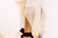 a classic neutral wedding dress paired with elegant black bow heels for a contrasting and super chic look at the wedding