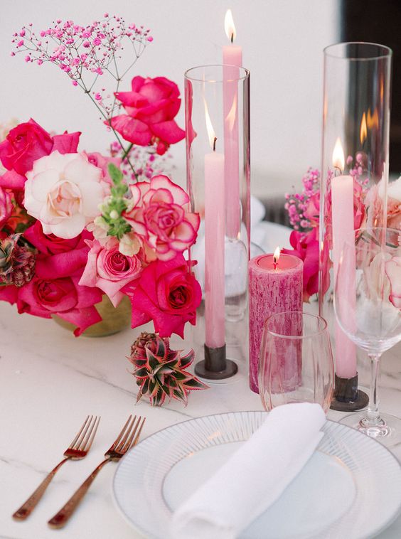 a beautiful and bold wedding tablescape with hot pink and white blooms, pink candles of various sizes, white porcelain is amazing