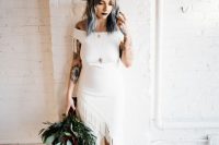 31 a plain off the shoulder boho wedding dress with fringe, a train, a brown hat, black boots with buckles and a greenery bouquet