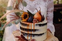 31 a statement fall naked wedding cake of chocolate, with pears, figs, greenery and blooms on top and some caramel drip