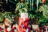 32 a white wedding cake decorated with white, orange, burgundy and red sugar petals is a very creative and bold idea for a modern wedding