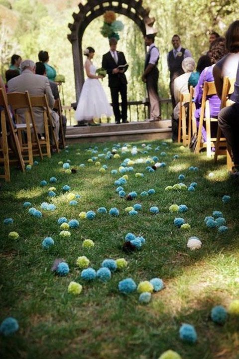 use colorful yarn pompoms instead of petals or blooms to line up the aisle and make your wedding unique and cheerful