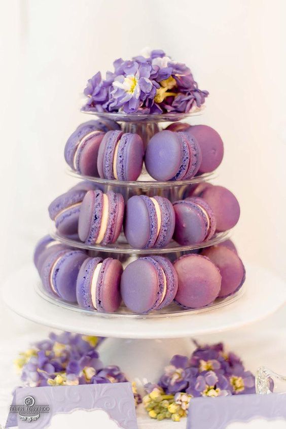 a mini purple macaron tower topped with purple blooms is a lovely alternative to a usual wedding cake, a great idea for a small wedding