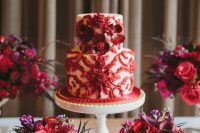 33 a white wedding cake with red patterns and red blooms is a very refined and chic idea for a wedding, it looks refined and bold