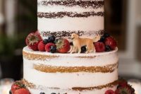 33 a yummy-looking naked four tier wedding cake topped with fresh berries and with a sugar dog topper is a fantastic idea