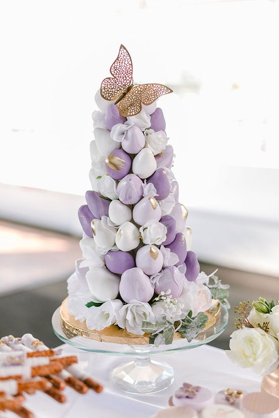 a purple and white chocolate dipper strawberry tower with gold brushstrokes and a gold butterfly on top is amazing