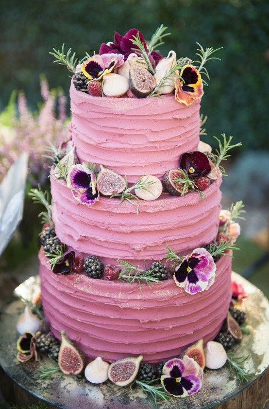 a bright pink textural wedding cake with greenery, blooms, fresh berries and mini meringues is a fantastic and chic idea