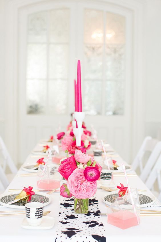 a pretty modern wedding tablescape done in black and white, with light and hot pink blooms, hot pink candles, pink punch and printed porcelain is a lovely idea