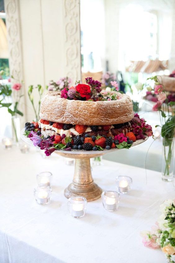 a bundt wedding cake filled with whipped cream, with bold blooms and fresh berries is a fab idea for a summer wedding and can be used for a fall one, too