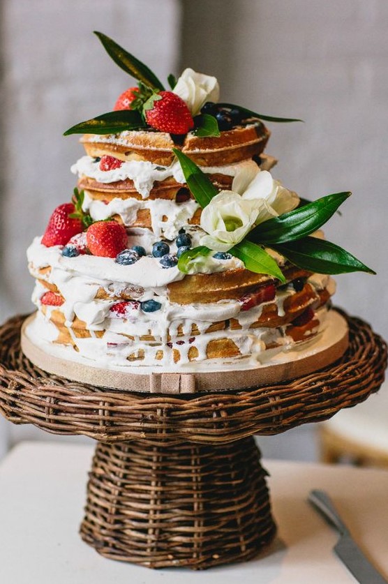 a delicious waffle wedding cake with cream drip, fresh berries, foliage and white blooms is very summer-like