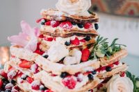 56 a gorgeous summer boho wedding cake with fresh berries, pink and white blooms, greenery and feathers on top