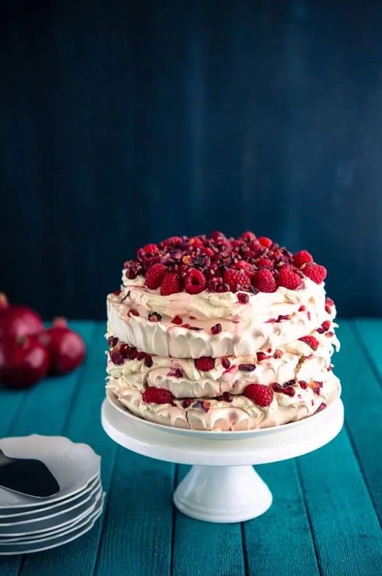 a pretty pavlova wedding cake with fresh raspberries and pomegranate seeds is a delicious wedding cake alternative